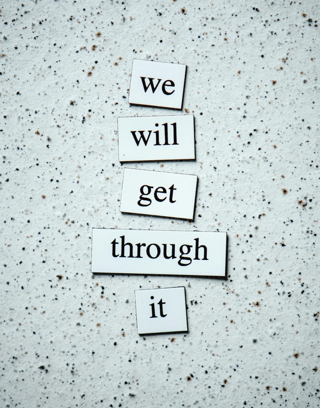 Motivational message "we will get through it" on a textured background for encouragement.